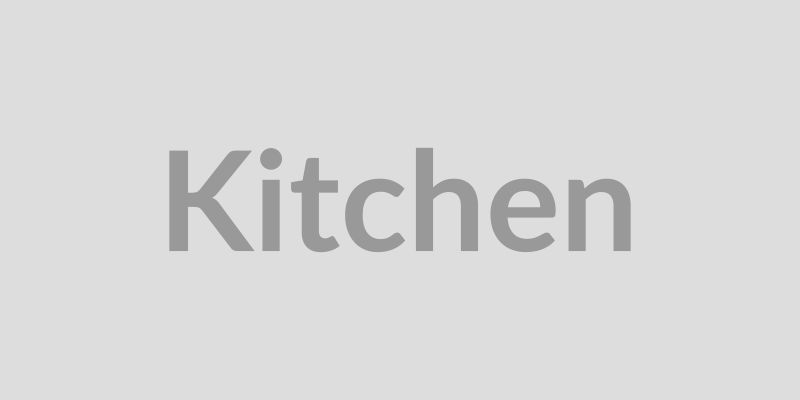Professional commercial kitchen with a chef checking a modern Kitchen Display System (KDS)